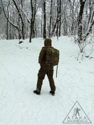 Силуэт человека с рюкзаком на фоне снега резко выделяется